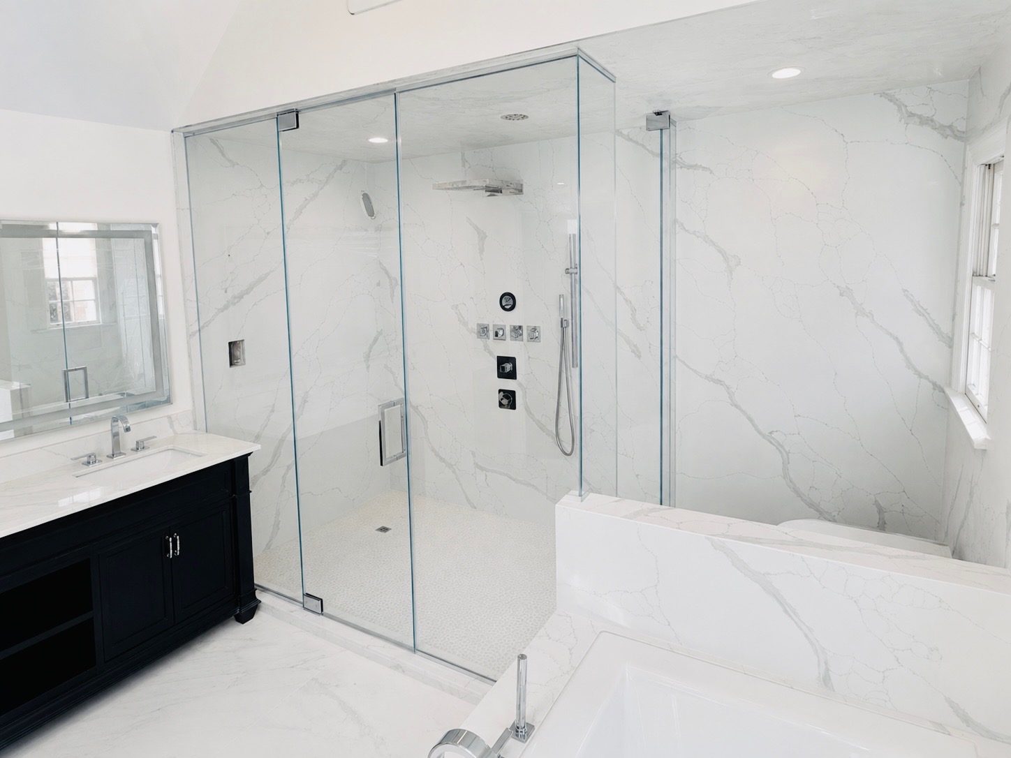 Large frameless enclosure in white marble with chrome fixtures