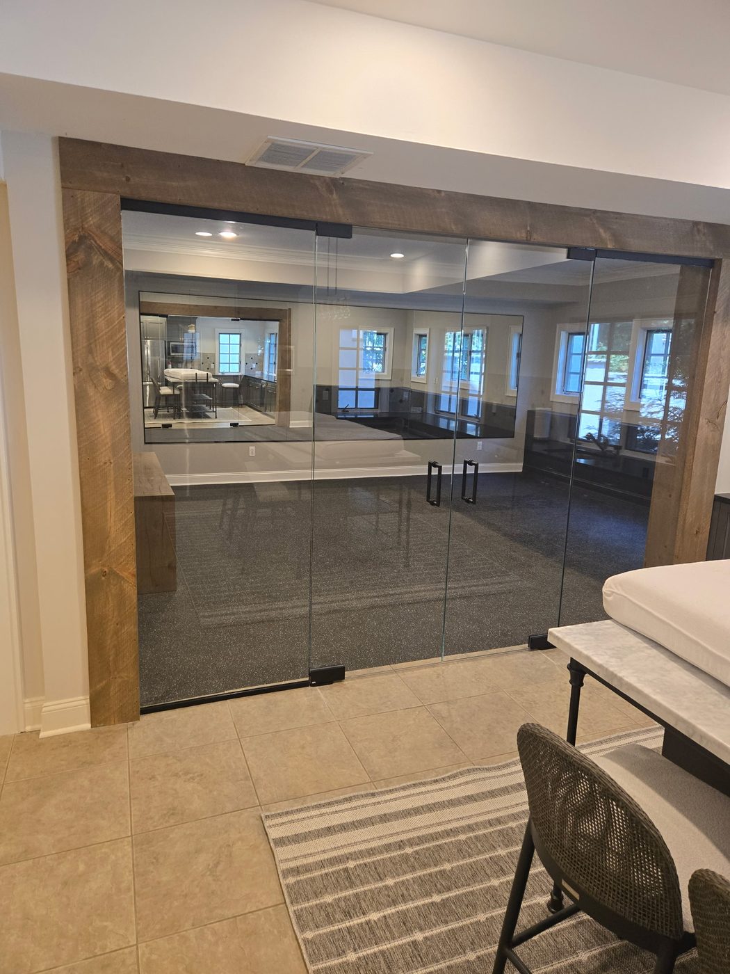 Frameless glass partition wall in a wood-framed opening