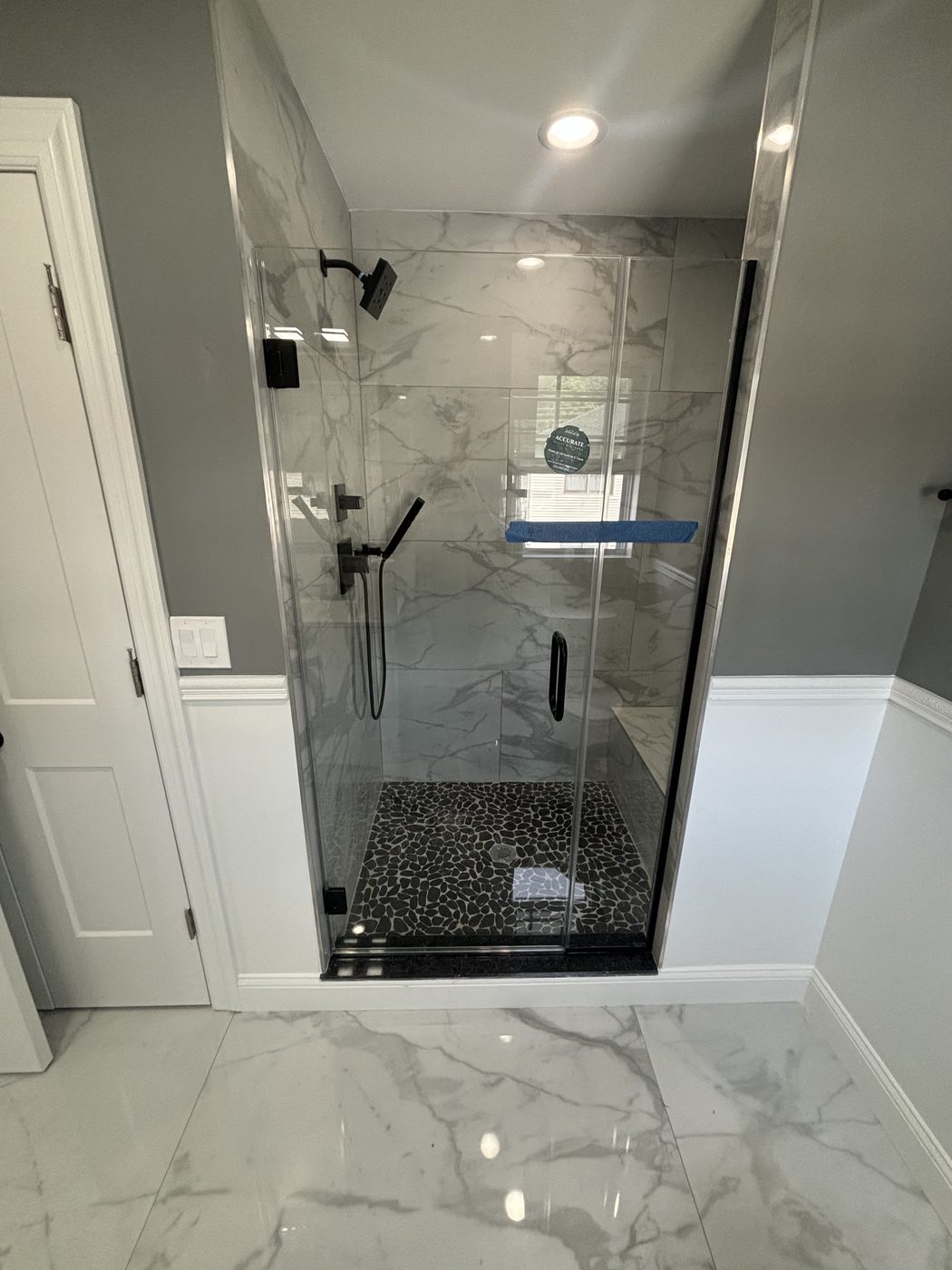 Large frameless mirror over a marble double vanity