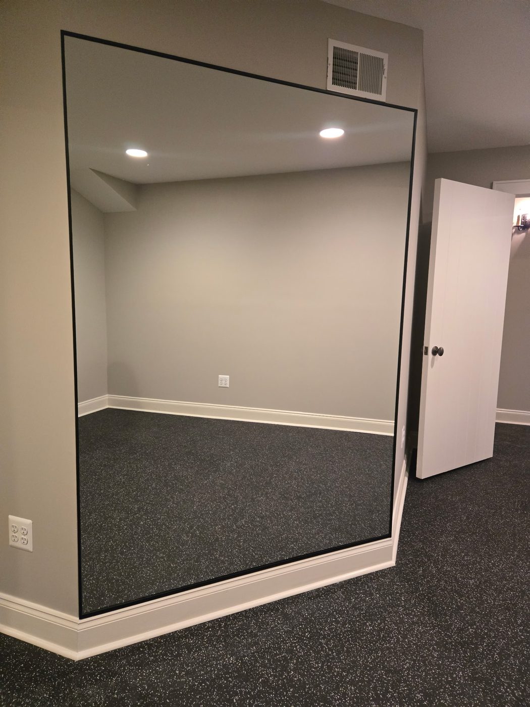 Oversized black-framed mirror in a fitness studio