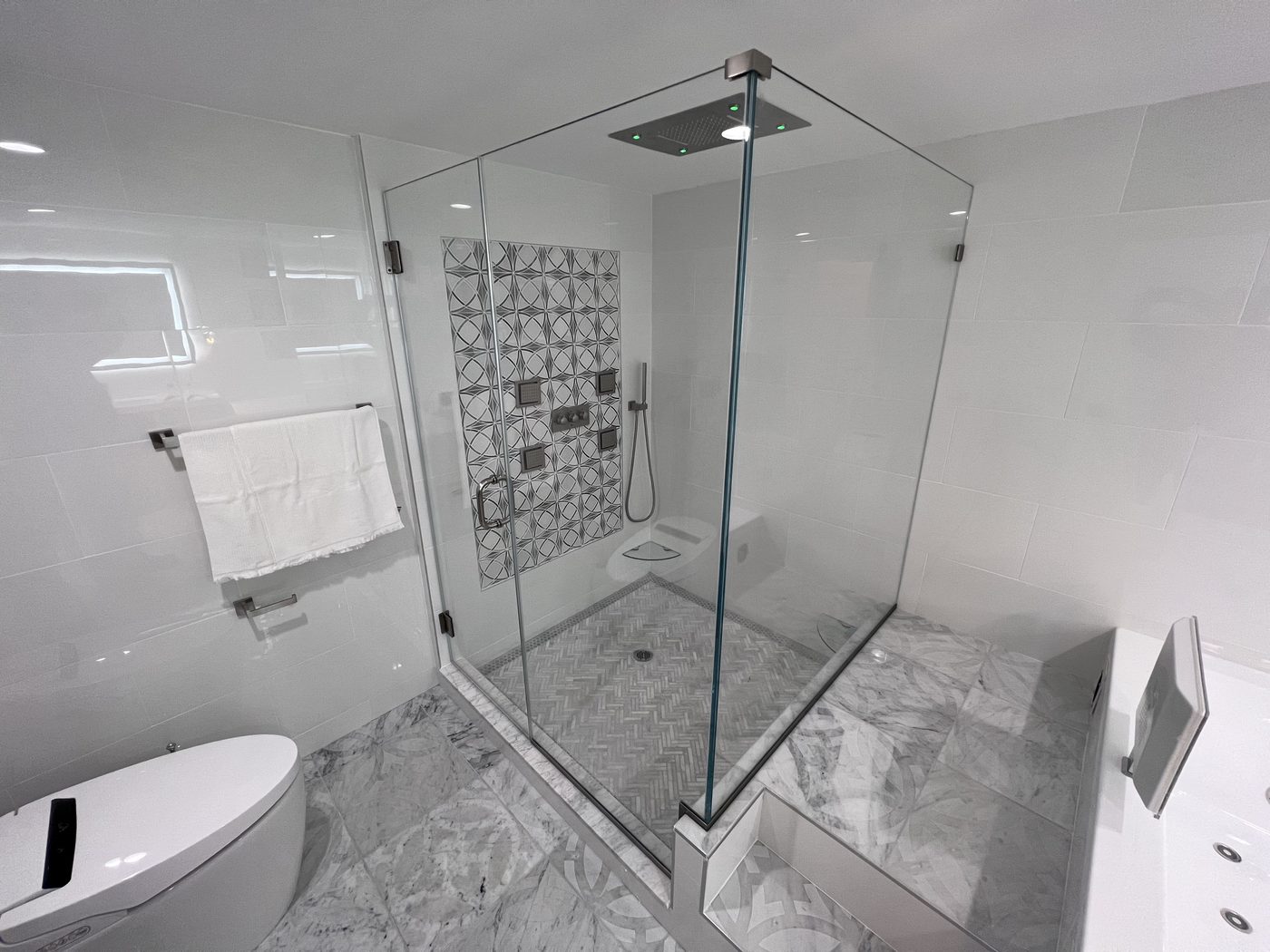 Neo-angle frameless glass shower with decorative tile