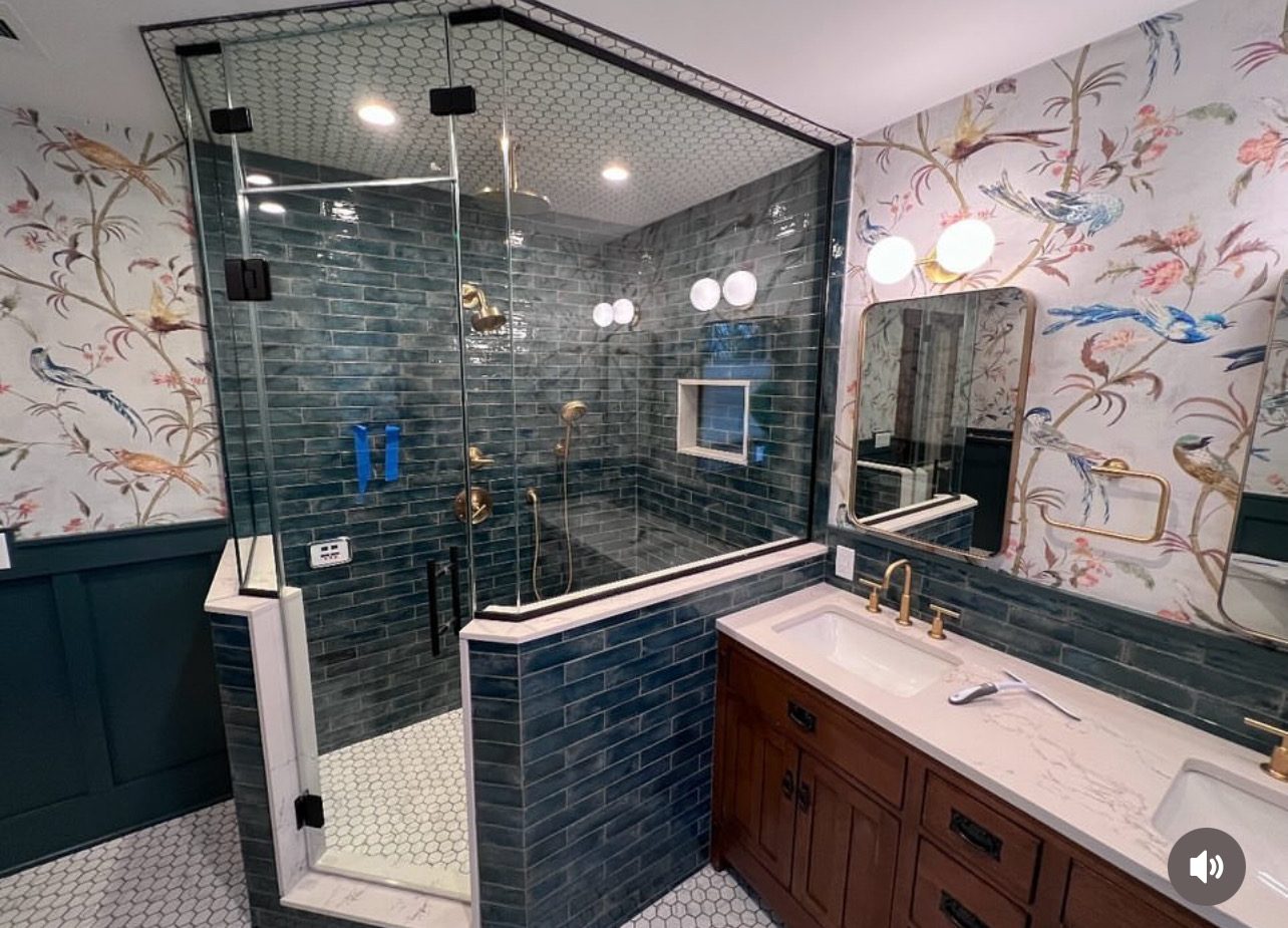 Frameless glass shower with blue tile and wood vanity