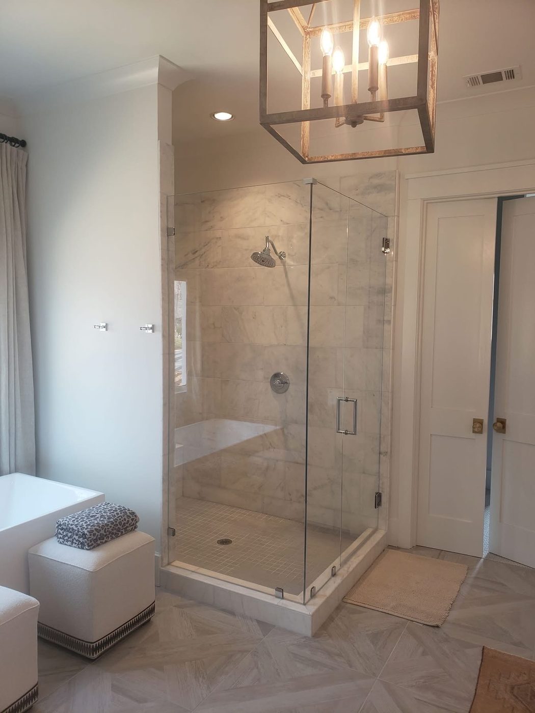Neo-angle frameless glass shower with marble and bench